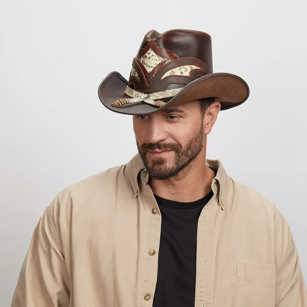 Man with light stubble wearing a Brown Storm Cowboy Hat, looking downwards to his right with a subtle smile.