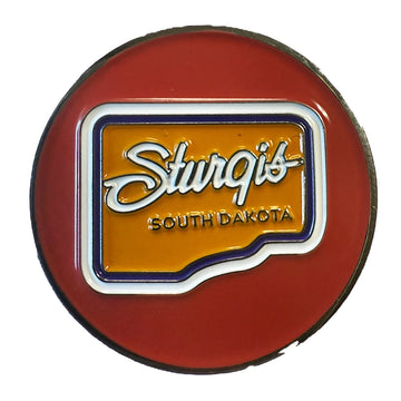 A circular red Sturgis South Dakota novelty pin or badge featuring a yellow-orange center with white script lettering and blue border details, shown on a plain white background.