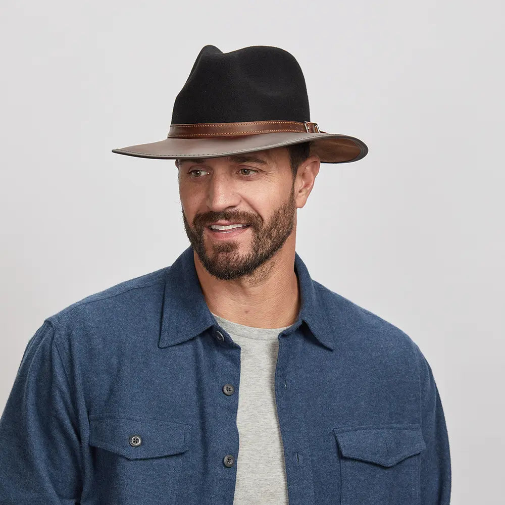 A man wearing the Summit Coal Felt Leather Fedora Hat, looking slightly to the side.