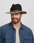 A man wearing the Summit Coal Felt Leather Fedora Hat, looking slightly to the side.