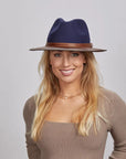 A blonde woman wearing a Navy Felt Fedora Hat and a beige fitted top.