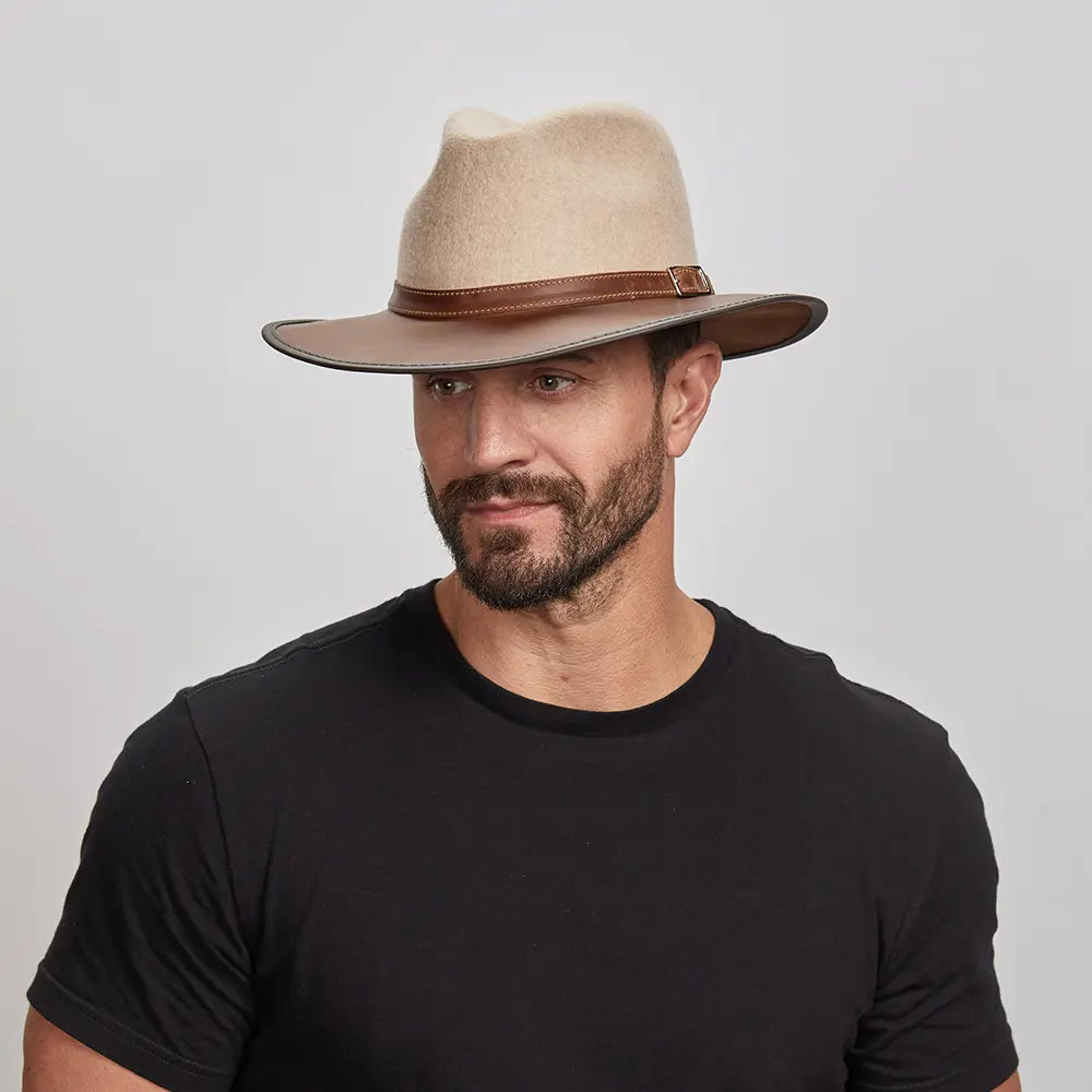 A man wearing the Summit Oatmeal Felt Leather Fedora Hat, looking slightly to the side.