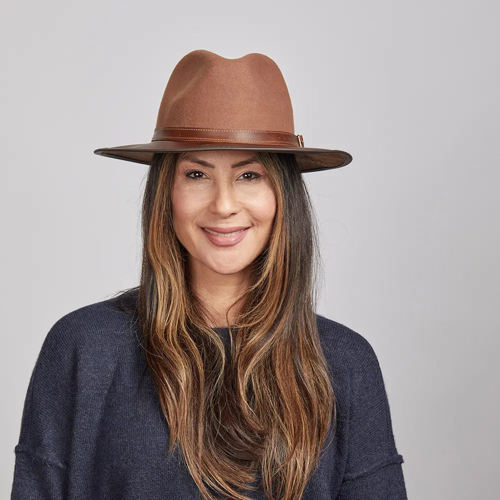 Woman with long brown hair wearing a Saddle Felt Fedora Hat and a navy blue sweater.