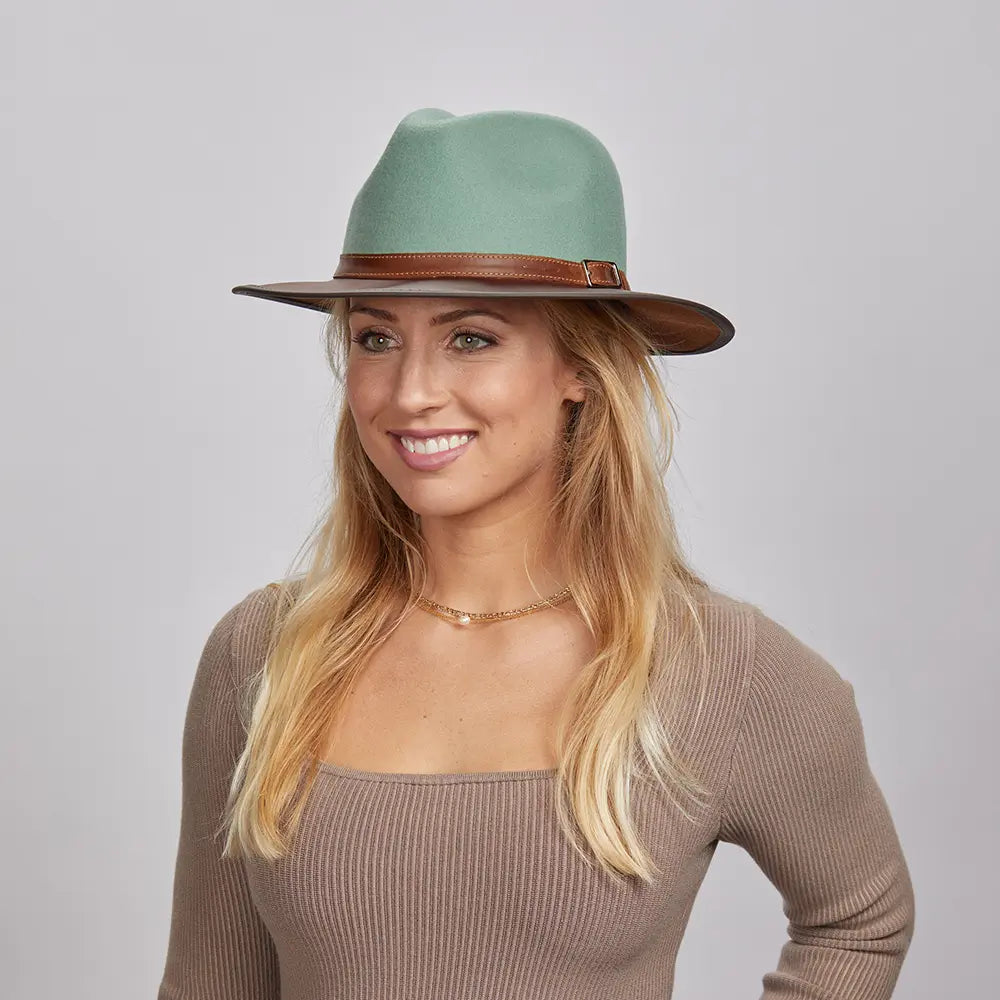 A blonde woman wearing a Sage Felt Fedora Hat and a beige fitted top.