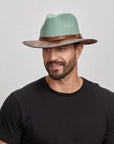 A man wearing the Summit Sage Felt Leather Fedora Hat, looking slightly to the side.