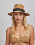 A blonde woman wearing a Beige Afternoon Fedora Hat and a brown knitted top.