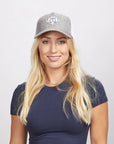 A blonde woman wearing a grey mesh poly cap and a blue shirt