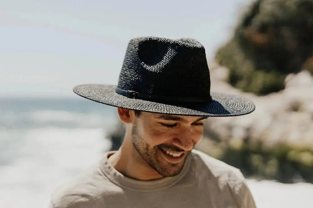 A man wearing a brown shirt and a black straw hat