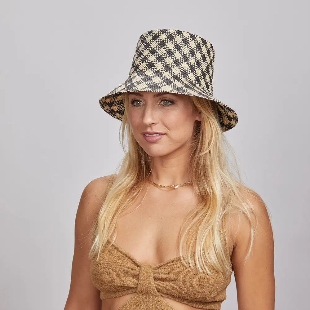 A blonde woman wearing a Tootie Bucket Hat and a brown knitted top, looking slightly to the side with a subtle smile.