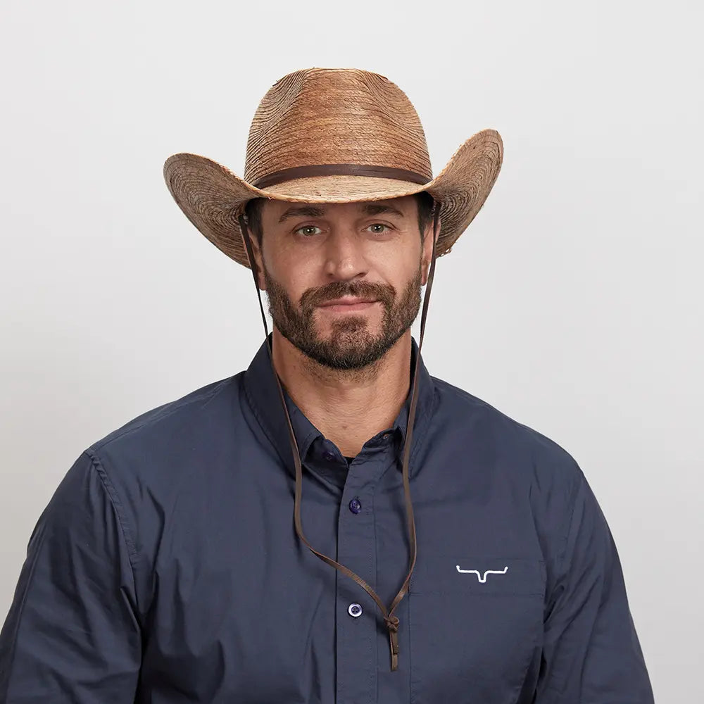 A smiling man in a navy blue polo wearing the Toast Cowboy Hat