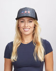 A blonde woman wearing a blue shirt and a black poly cap