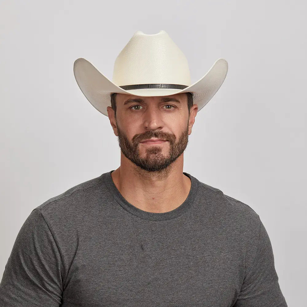 A young man in a grey shirt wearing an ivory cowboy hat