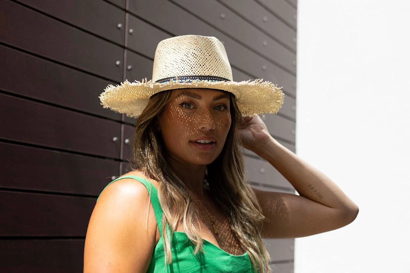 A woman in a green top wearing a straw sun hat
