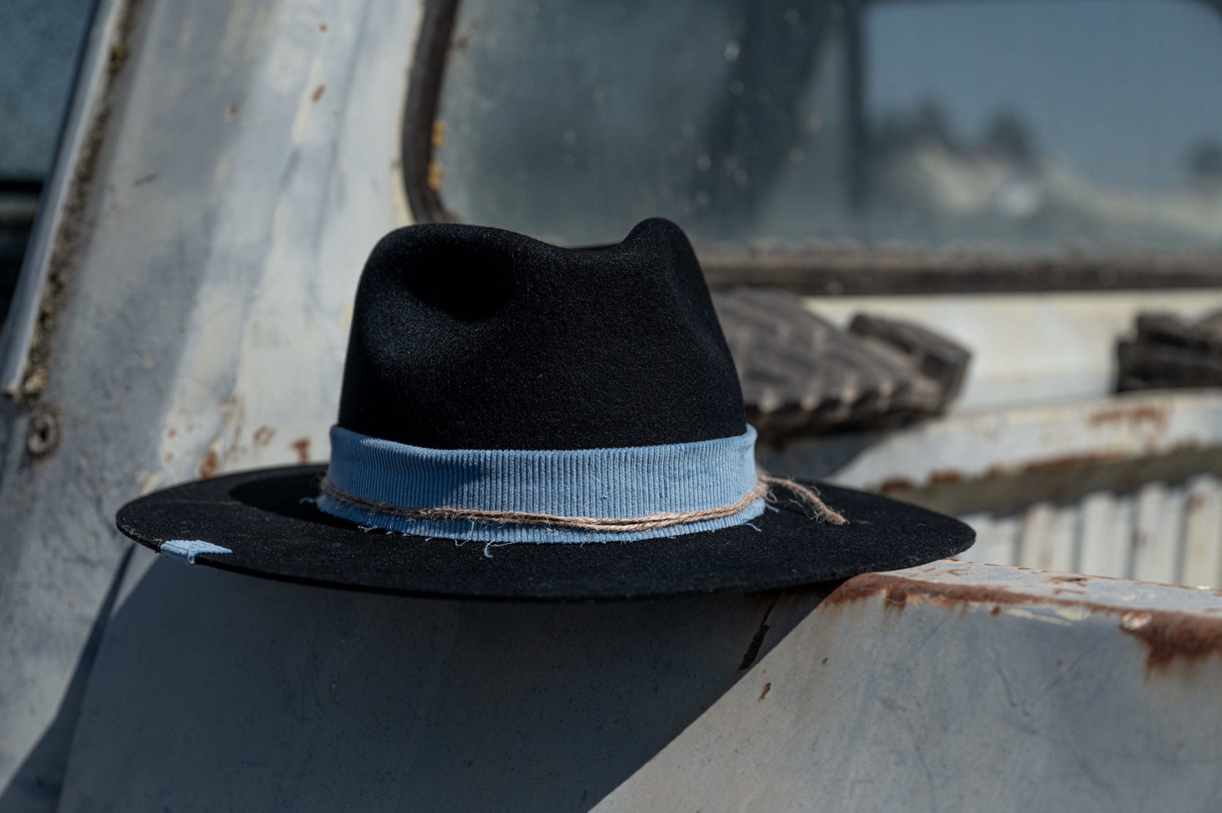 A black cowboy hat placed at the side of a truck
