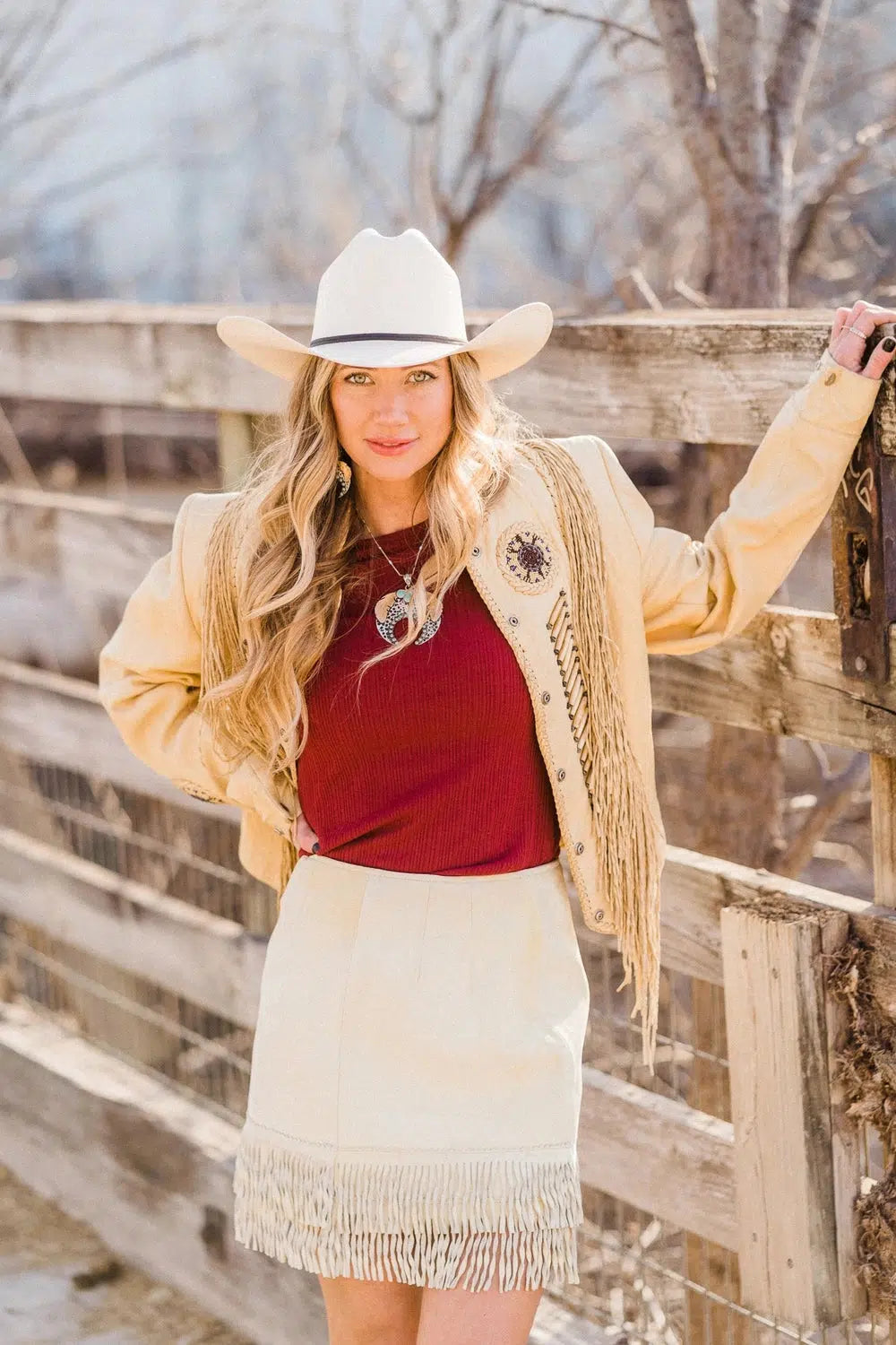 A blonde model wearing a brown jacket, red inner shirt, cream skirt with the Women FT Worth Cream 