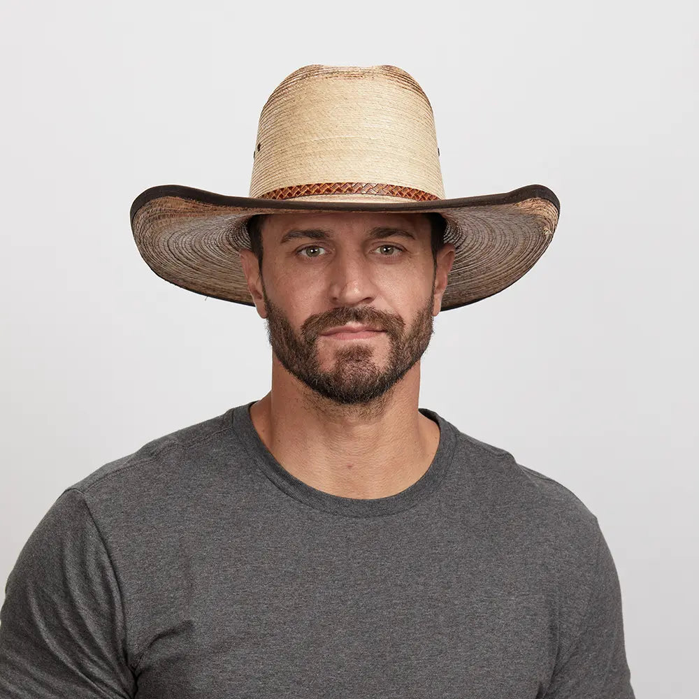 A man wearing a grey shirt and a natural straw cowboy hat