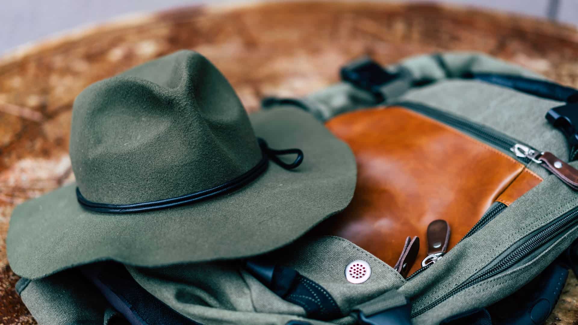 A felt hat placed on top of a gray bag