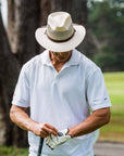 Man golfing while wearing the cream mens milan sun hat