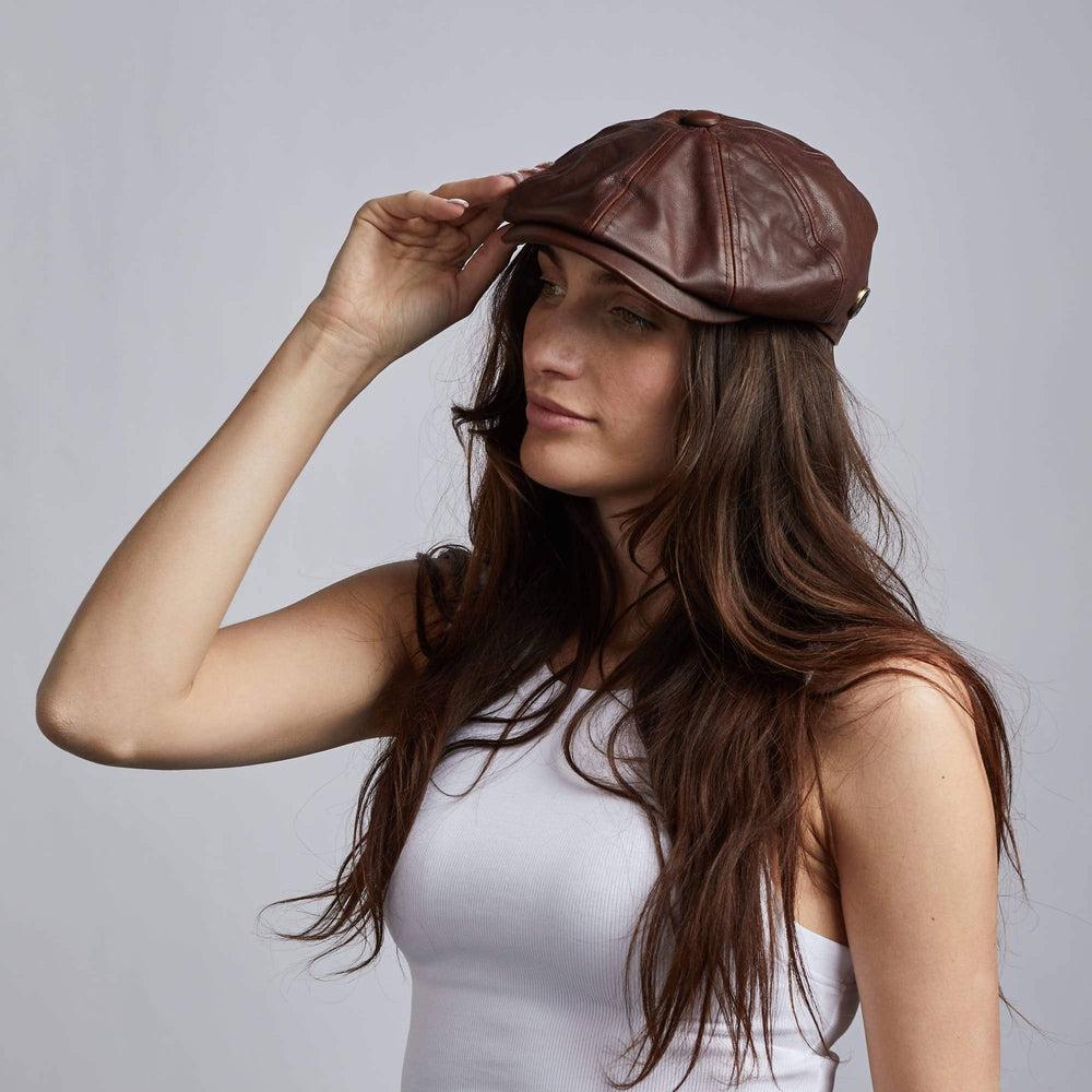 A woman wearing Bourbon St Leather Brown Cap holding it with right hand