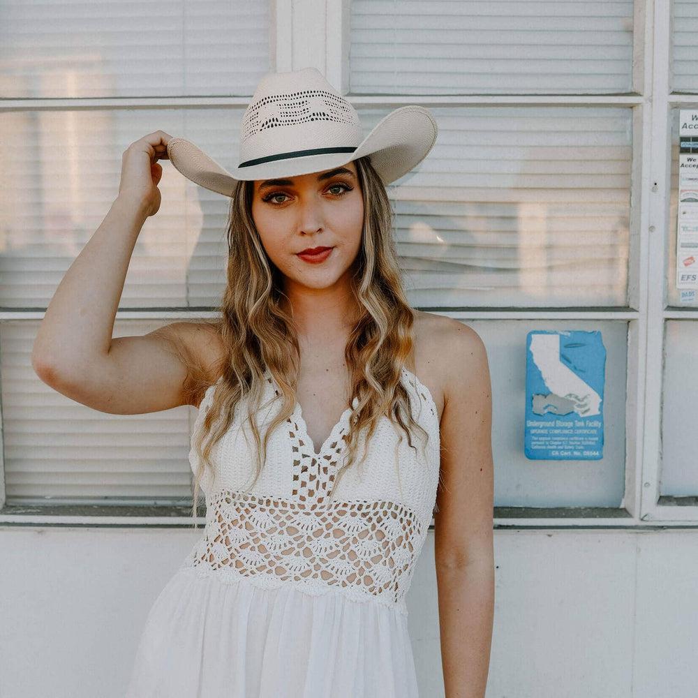 A woman in white dress wearing Bozeman Cream Straw Cowboy Hat 