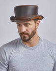 A man wearing Bromley Brown Leather Top Hat with a Carriage Band 