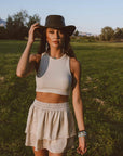 A woman standing in a yard wearing Leather Brown Bushman Outback Hat 