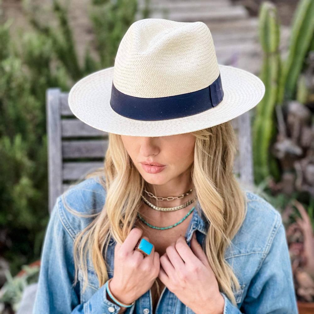 A woman in a garden wearing a denim jacket and a Panama Fedora Hat in a right view
