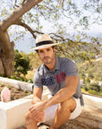 A man sitting on an overlooking view wearing  Panama Straw Fedora Hat 
