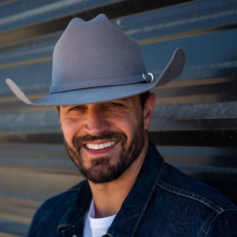 A smiling man wearing denim jacket and a Gunsmoke Cattleman Felt Cowboy Hat 