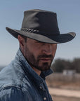 A man with a denim jacket and an Outback Leather Hat 
