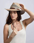 A woman wearing wide brim tan straw fedora cream hat on a front view