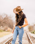 A woman in a rail track wearing black shirt and a Gorge Leather Cattleman Brown Cowboy Hat