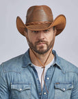 A man on a denim jacket wearing Hollywood Copper Leather Cowboy Hat 