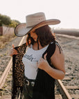 A woman in a railway track wearing Laredo Straw Tan Cowboy Hat 