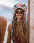 A woman wearing Lola Silver Burning Man Hat and a shades