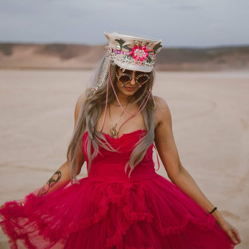 A woman in pink dress and wearing Lola Silver Burning Man Hat 
