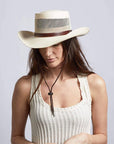 A woman wearing Madrid Straw Pork Pie Cream Sun Hat on an angle view 