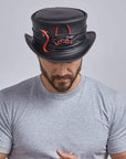 A man looking downwards wearing Marlow Lil Evil Black Leather Top Hat 