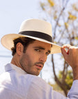 A man wearing White Panama Fedora Hat 