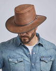 A man looking downwards wearing Midnight Rider Chestnut Leather Hat 