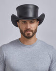 A man wearing Unbanded Pale Rider Black Leather Top Hat 