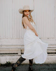 A woman in a white dress wearing Natural Vaquero Tejano Palm Cowboy Hat 