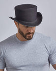A man wearing Unbanded Rogue Black Mesh Top Hat on an angle view
