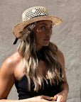 A side view of a woman wearing Saunter Natural Straw Sun Hat 