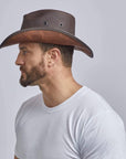 A man looking sideview wearing Stockade Brown Vegan Cowboy Hat 