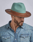 A man wearing a Summit Sage Felt Leather Fedora Hat on a left view