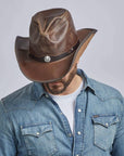A man looking down wearing Chocolate Leather Cowboy Hat with 3" Brim and 4" Crown
