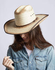 A woman wearing Yuma Tan Straw Palm Cowboy Hat