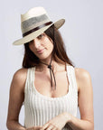 A woman with head bend a little wearing a Cream Straw Fedora Hat 