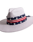 A side view of Knox white straw sun hat with US flag designed hat band